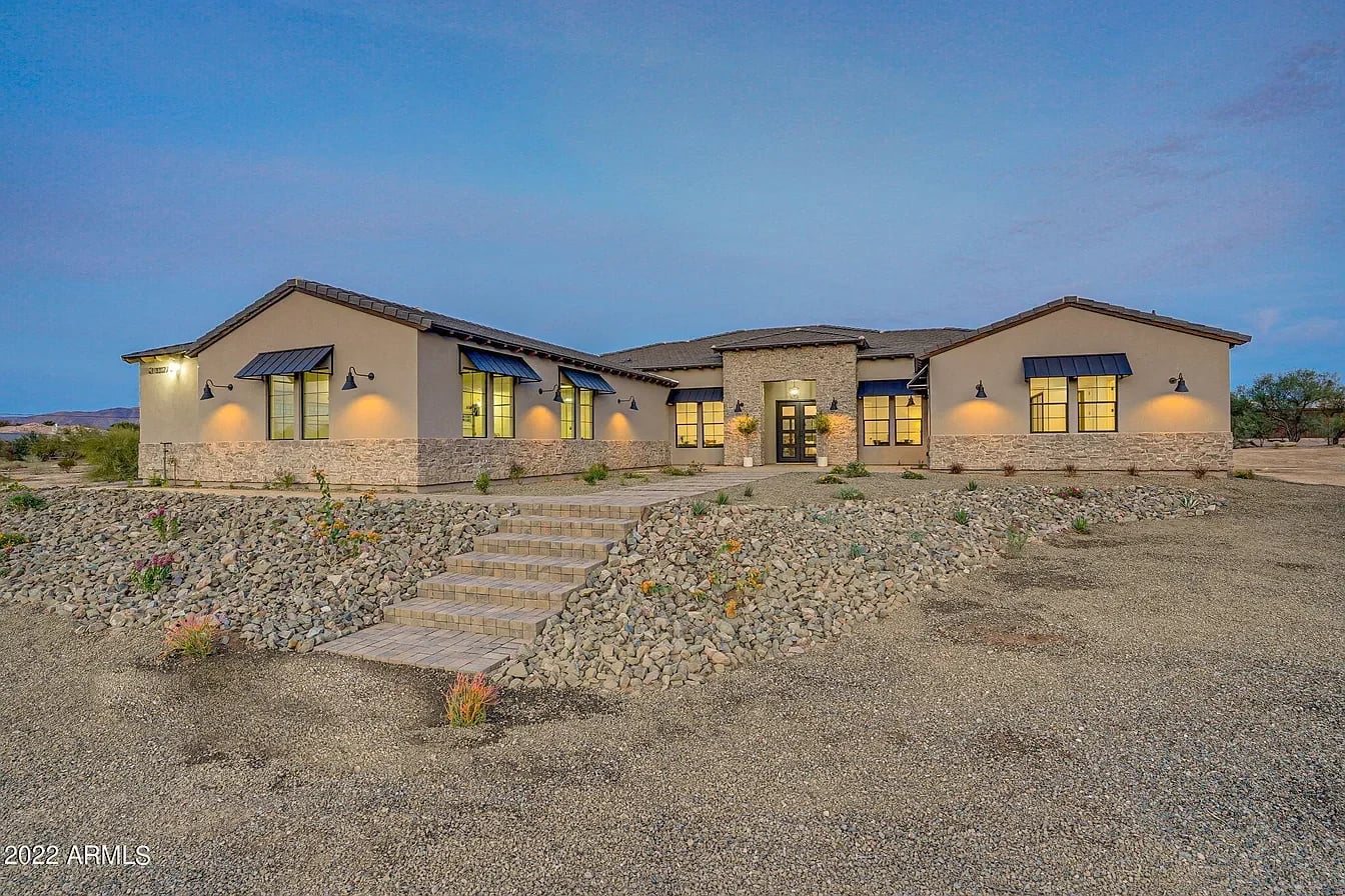 The Hayden residence at twilight, with an illuminated stone-and-stucco exterior.