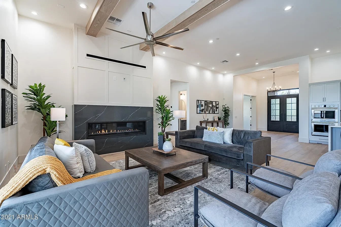 A beamed great room with a linear fireplace and open living space.