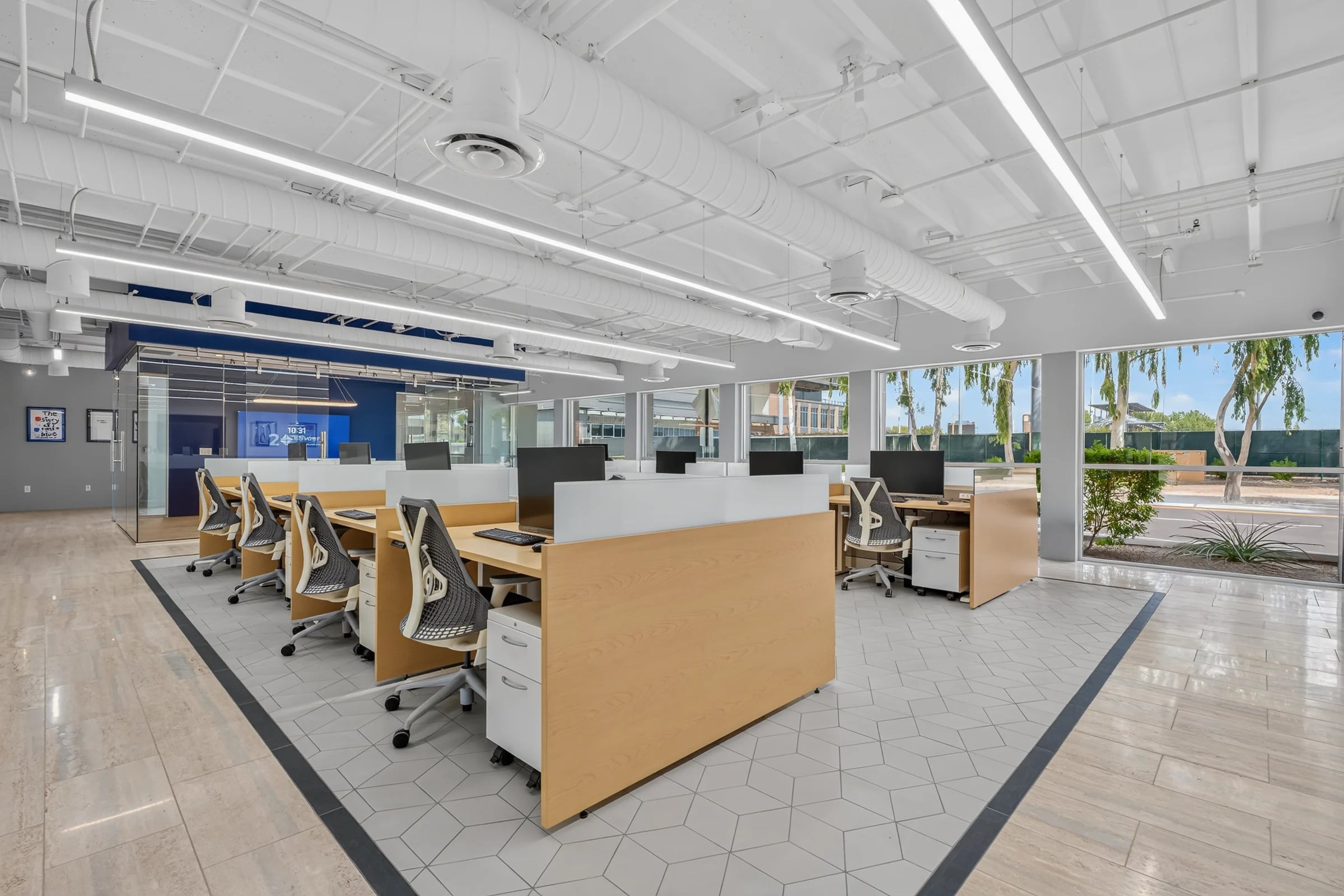 An open office with exposed ductwork and linear lighting.