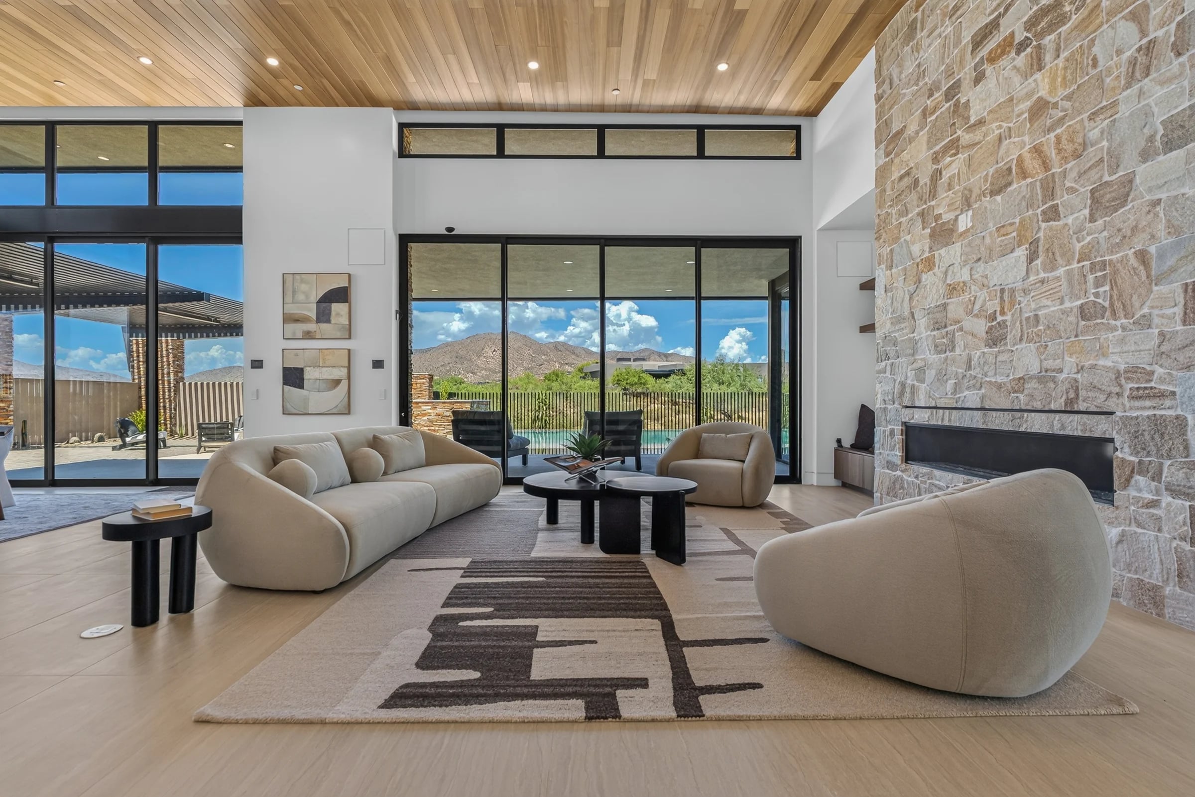 A stone fireplace and timber ceiling in Salero’s living room, with full-height views to the desert.